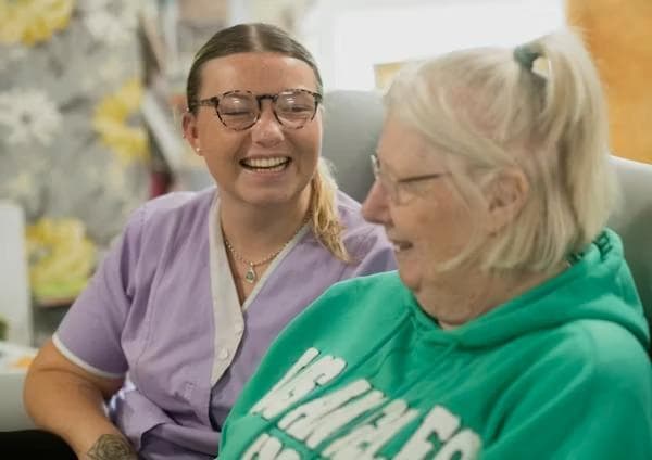 Care worker laughing with a resident